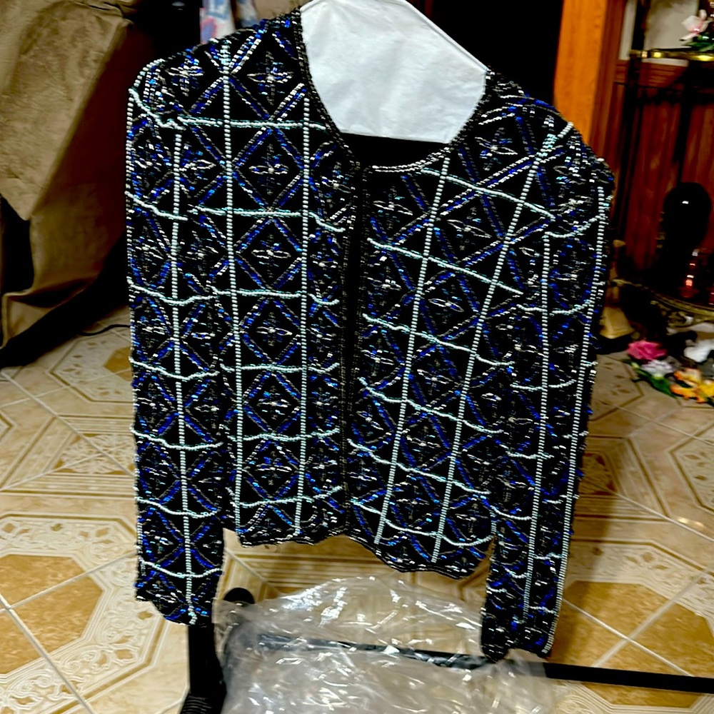 Jacket black background with blue and silver sequins. Long sleeve.